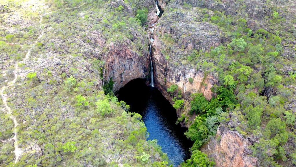 Wasserfall inmitten von Felsen, umgeben von Wald im Litchfield National Park